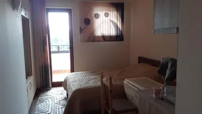 a small bedroom with a bed and a window at Hotel Grand Resor Pamporovo in Pamporovo