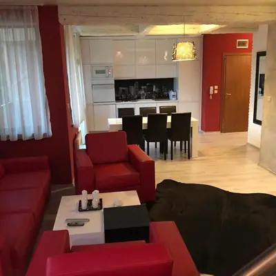 a living room with red furniture and a kitchen at Sequoia Loft apartment in Borovets