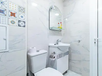 a white bathroom with a toilet and a sink at Stay & Explore Sofia - Central Studio in Sofia