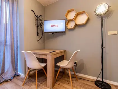 a room with a desk and two chairs and a tv at Stay & Explore Sofia - Central Studio in Sofia