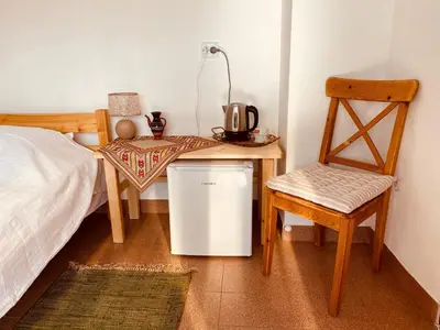a room with a bed and a table and a chair at Vita Stulba Guest House in Sandanski
