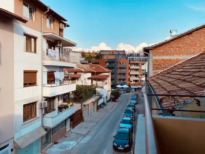 a city street with parked cars and buildings at Vita Stulba Guest House in Sandanski