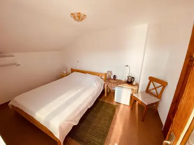 a bedroom with a bed and a table and a chair at Vita Stulba Guest House in Sandanski