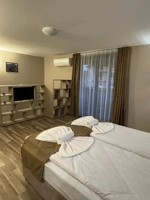 a bedroom with a large bed and a television at Къща Александра 2 in Dobrinishte