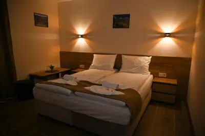 a hotel room with a bed with two towels on it at Къща Александра 2 in Dobrinishte