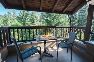 a patio with two chairs and a table on a deck at Arni Aparts 1 in Velingrad