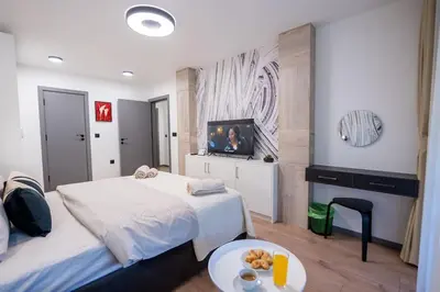 a hotel room with two beds and a flat screen tv at Arni Aparts 1 in Velingrad