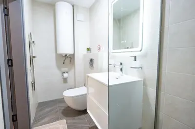 a white bathroom with a toilet and a sink at Arni Aparts 1 in Velingrad