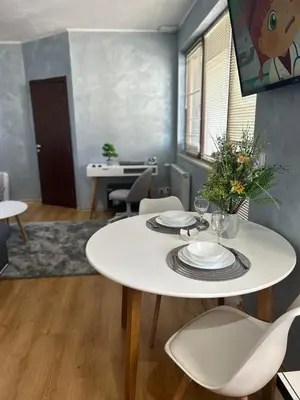 a dining room with a white table and chairs at 1-Bedroom apt - BathTub - 10mins from SkiLift Gondola - freeWiFi - WorkDesk - Central Heating - Full Kitchen at Edelweiss in Bansko