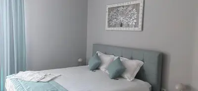 a bedroom with a bed with blue and white pillows at Apartmenthaus Oborishte - 17 in Panagyurishte