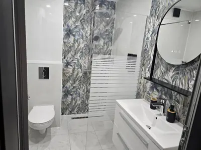 a bathroom with a toilet and a sink and a mirror at Apartmenthaus Oborishte - 17 in Panagyurishte