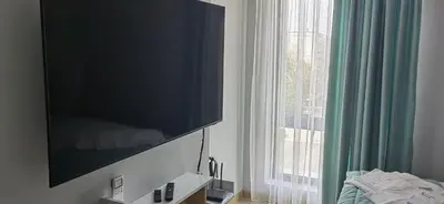 a flat screen tv on a wall next to a window at Apartmenthaus Oborishte - 17 in Panagyurishte