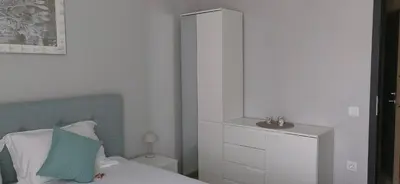 a white bedroom with a bed and a mirror at Apartmenthaus Oborishte - 17 in Panagyurishte