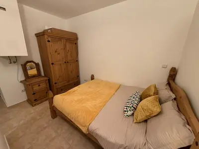 a bedroom with a bed and a dresser in a room at Pine`s Lodge - Cozy studio with free Bottle of Wine, private WiFi, free Parking in Bansko