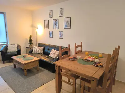 a living room with a table and a couch at Pine`s Lodge - Cozy studio with free Bottle of Wine, private WiFi, free Parking in Bansko