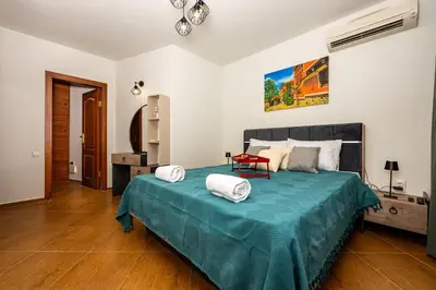 a bedroom with a large bed with a blue blanket at Апартамен за гости Панови in Plovdiv