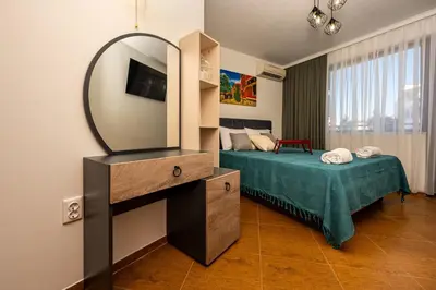 a bedroom with a bed and a mirror on a dresser at Апартамен за гости Панови in Plovdiv