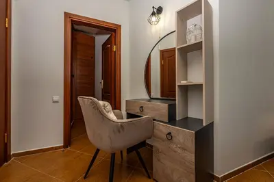 a room with a chair and a dresser with a mirror at Апартамен за гости Панови in Plovdiv