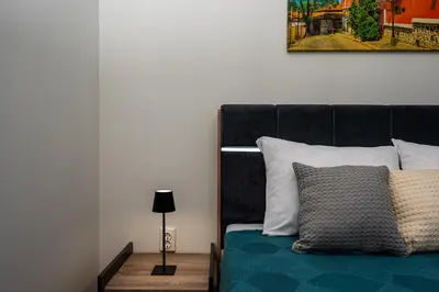 a bedroom with a bed with a black headboard at Апартамен за гости Панови in Plovdiv