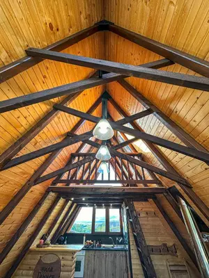 a ceiling of a wooden cabin with a window at Алпийска вила в полите Рила in Resilovo