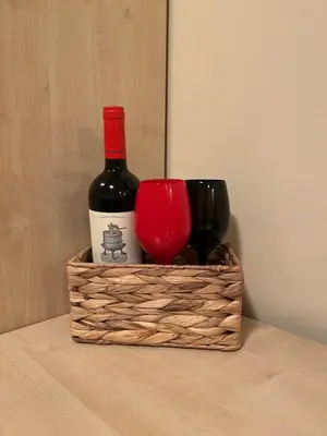 a basket with two bottles of wine on a table at Aspen Suites Студио Слънчев ден in Razlog