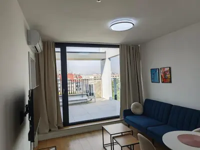 a living room with a blue couch and a large window at My Campus 1 bdrm, Romantic, Panorama view, Free parking, Self check-in in Sofia