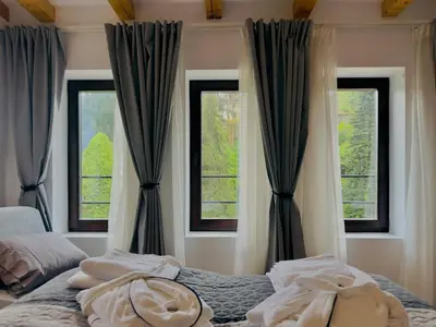 a bedroom with two windows and a bed at Spa Villa Mezinska Jacuzzi Sauna in Shiroka Lŭka