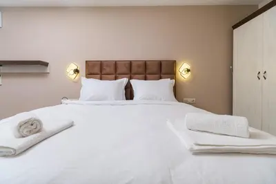 a bed with white sheets and towels on it at LDV 13 1-Bedroom Apartments Free private parking in Plovdiv
