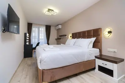 a bedroom with a large bed and a television at LDV 13 1-Bedroom Apartments Free private parking in Plovdiv