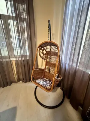 a wicker rocking chair sitting in front of a window at Prime Stays at 34 Bratya Miladinovi Street in Sofia