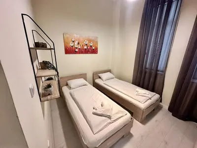 a room with two beds and a painting on the wall at Prime Stays at 34 Bratya Miladinovi Street in Sofia