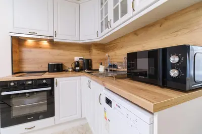 a kitchen with white cabinets and a black microwave at LDV 13 Apartments Free private parking in Plovdiv