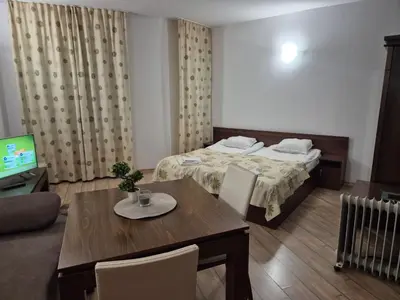 a room with a bed and a table and a television at Stream Spa Suite in Pamporovo