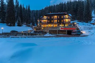 a large house in the snow at night at Stream Spa Suite in Pamporovo