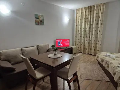 a living room with a table and a couch at Stream Spa Suite in Pamporovo