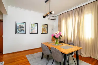 a dining room table with a vase of flowers on it at Charming 2BD Apartment in the Heart of the City by Flat Mаnager in Sofia