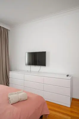 a bedroom with a flat screen tv on a white wall at Charming 2BD Apartment in the Heart of the City by Flat Mаnager in Sofia