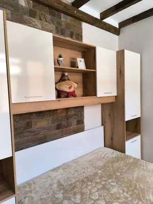 a bedroom with white cabinets and a brick wall at Snow White - Luxury Stay with free Bottle of Wine in Bansko
