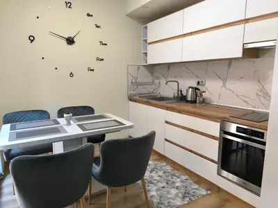 a kitchen with a table and chairs and a clock on the wall at Snow White - Luxury Stay with free Bottle of Wine in Bansko