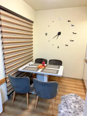 a table and chairs in a room with a clock on the wall at Snow White - Luxury Stay with free Bottle of Wine in Bansko