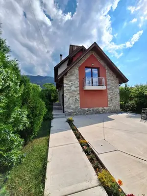 a small brick house with a balcony on a sidewalk at Guest House Vessyta in Sapareva Banya