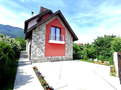 a small house with a red door and a balcony at Guest House Vessyta in Sapareva Banya