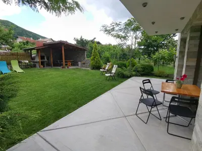 a patio with chairs and a grass yard at Guest House Vessyta in Sapareva Banya