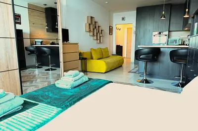 a living room with a yellow couch and a kitchen at Best View Studio in Sofia