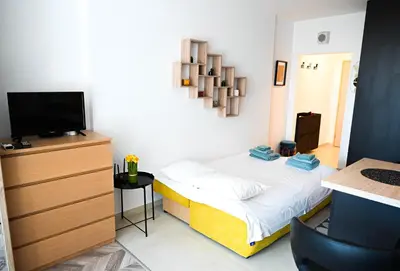 a small bedroom with a bed and a television at Best View Studio in Sofia