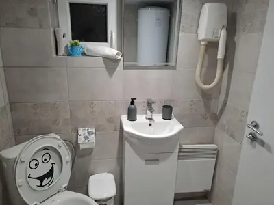 a bathroom with a toilet with a smiley face drawn on it at Къща за гости Съкровище in Panagyurishte
