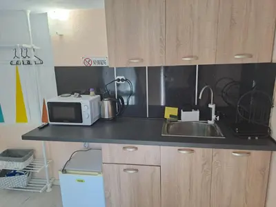 a kitchen counter with a microwave and a sink at Къща за гости Съкровище in Panagyurishte
