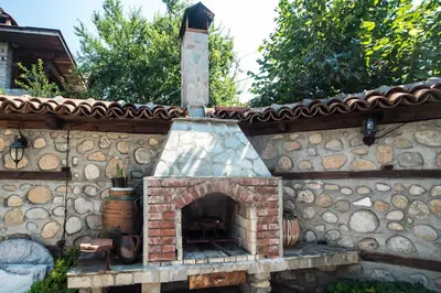 an outdoor brick oven with a stone wall at Todeva House Hotel and Tavern in Bansko
