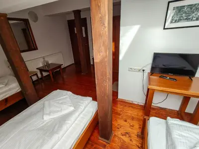 a room with a bed and a tv and a table at Todeva House Hotel and Tavern in Bansko