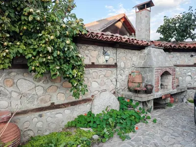a stone building with a stone oven in a garden at Todeva House Hotel and Tavern in Bansko